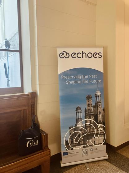 Roll-Up with the announcement of the second ECHOES Annual Event in Poznań (16.–20.03.2026). And our sneaky little NFDI4Culture bag is just beside it!
